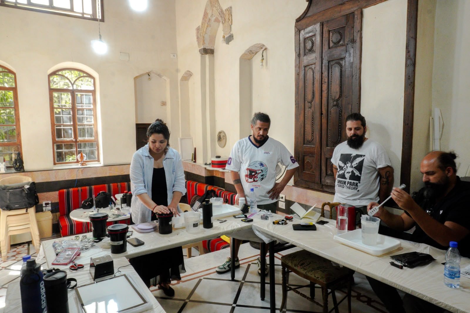 Participants pouring chemistry during a film developing workshop, Damascus, September 2026